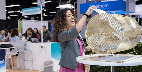 A smiling attendee adds her passport to the prize drum.