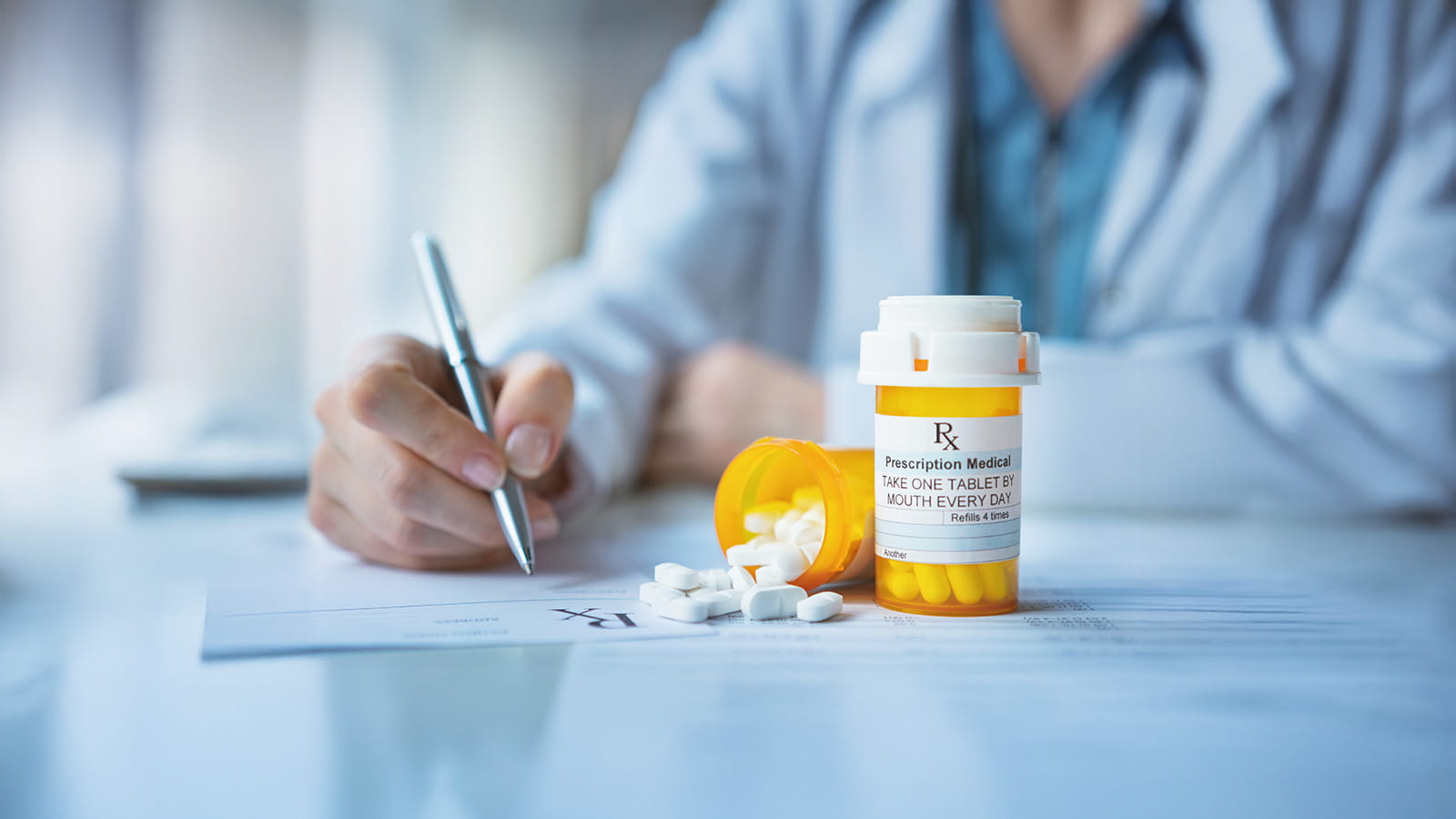 Close up of a doctor prescribing pills