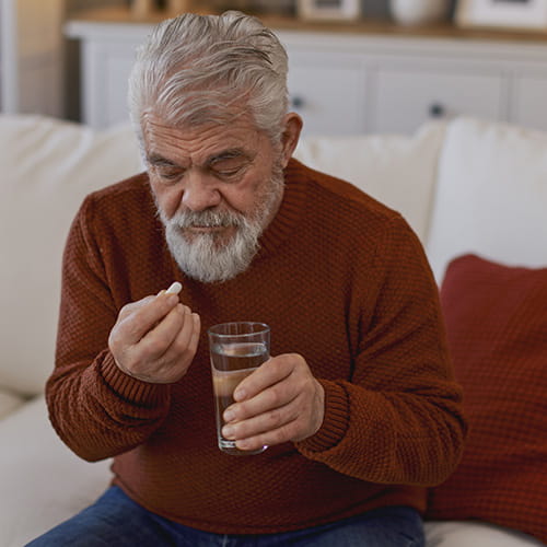 Man taking a pill on a couch